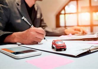 persona escribiendo sobre una libreta, con un carro de juguete cerca, sobre un escritorio, seguro con plan de retiro.