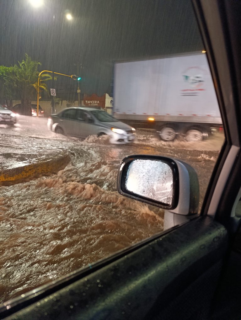vista de una calle desde un auto, para mostrar  intensa lluvia e inundación